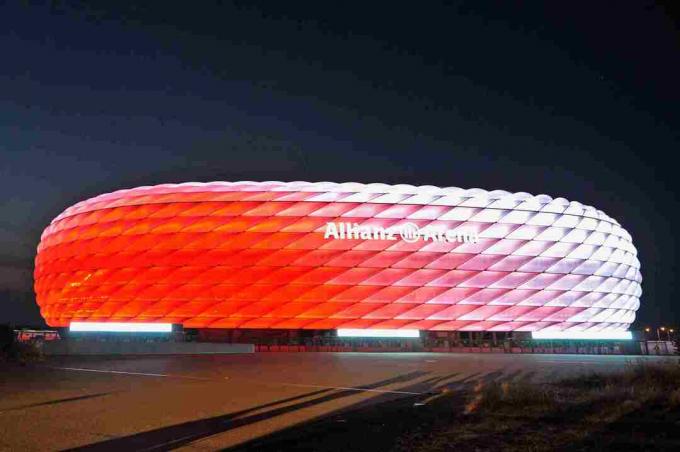 bijelo danonoćno, urezana vanjština Allianz Arene noću svijetli crveno