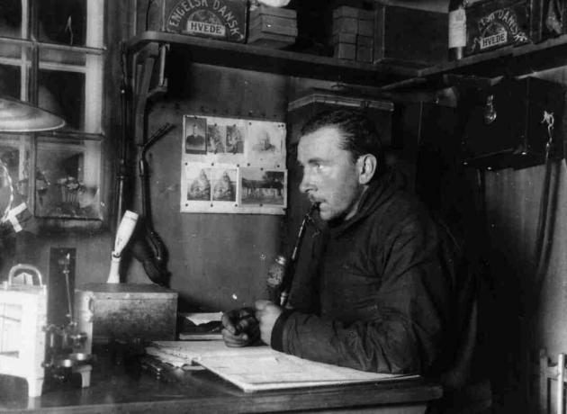 Alfred Wegener koji radi za svojim stolom, crno-bijela fotografija.