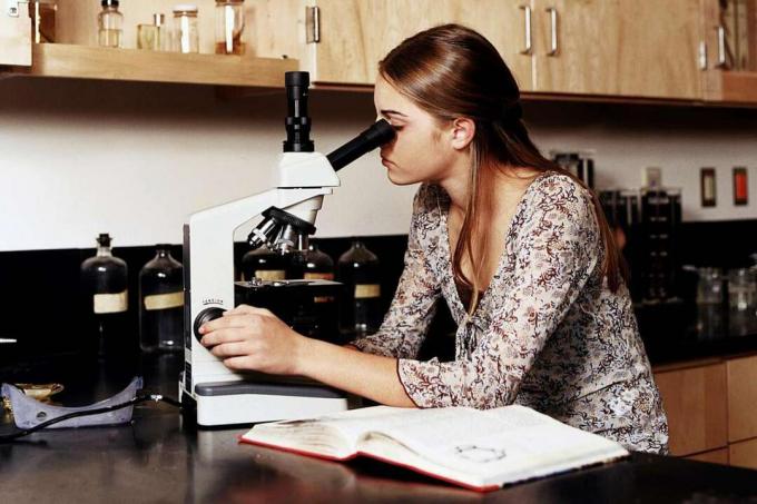 Djevojčica (14-16) pomoću mikroskopa u nastavi znanstvenog laboratorija