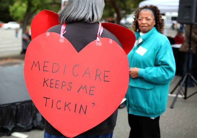 Žena nosi natpis u obliku srca s natpisom " Medicare me drži kucanjem"
