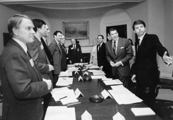 Crno -bijela slika Ronalda Reagana i nekoliko drugih muškaraca u odijelima oko dugog konferencijskog stola