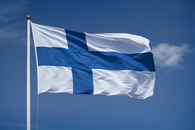 Istaknuta finska zastava s pozadinom plavog neba