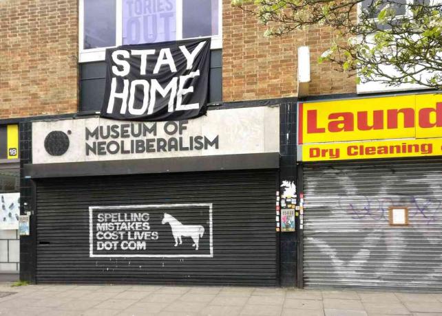 Veliki znak STAY HOME iznad zatvorenog muzeja neoliberalizma u Lewsihamu u Londonu u Engleskoj.